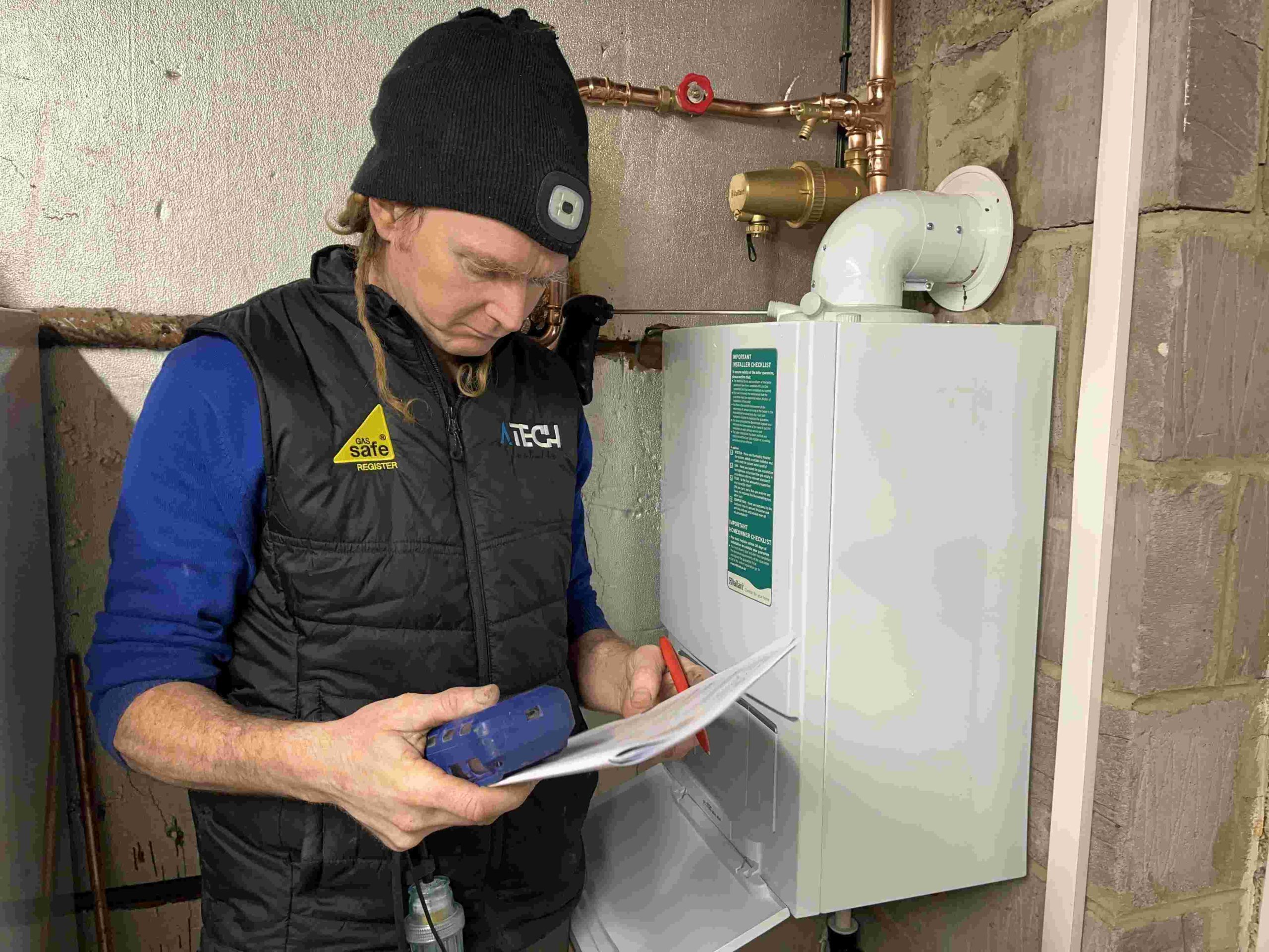 How Much Does a Boiler Cost in 2025 – Boiler Installation Leeds Gas Safe engineer commissioning a new boiler installation with paperwork in Leeds — A Tech Installs
